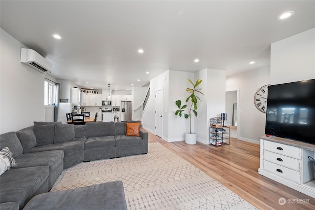 living room featuring a wall unit AC and light wood-type flooring