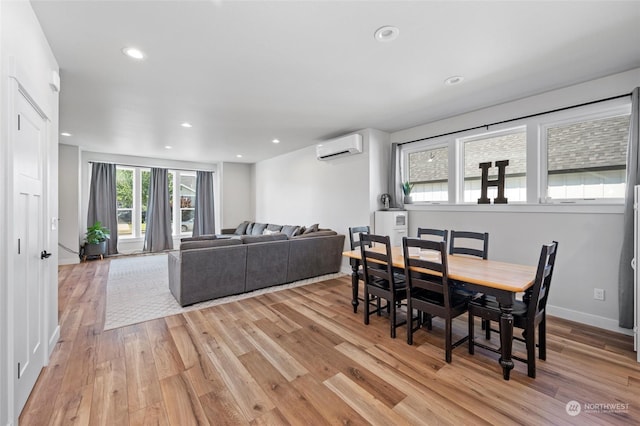 dining area featuring a wall unit AC and light hardwood / wood-style flooring