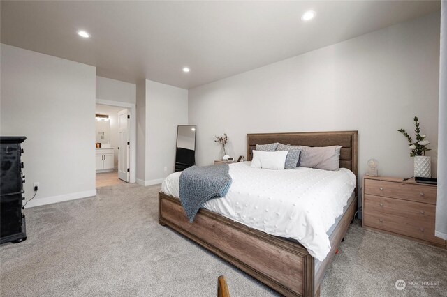 bedroom with light colored carpet and connected bathroom