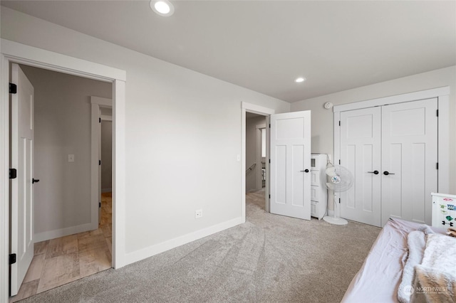 unfurnished bedroom with a closet and light carpet