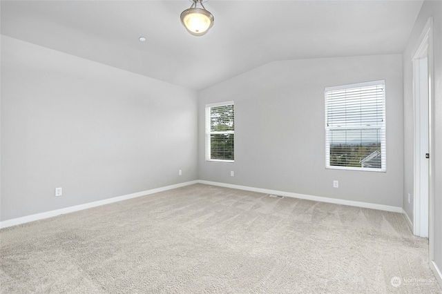 carpeted empty room with vaulted ceiling