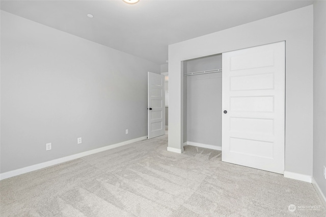 unfurnished bedroom featuring light colored carpet and a closet