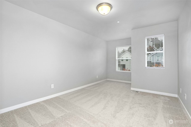 unfurnished room featuring light colored carpet