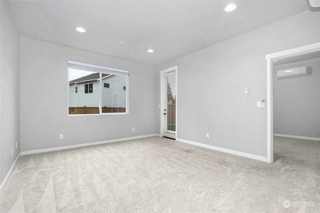 spare room featuring an AC wall unit and light carpet