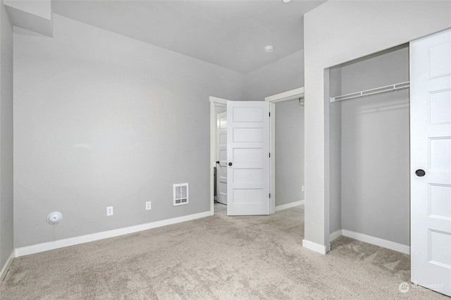 unfurnished bedroom featuring a closet and light carpet