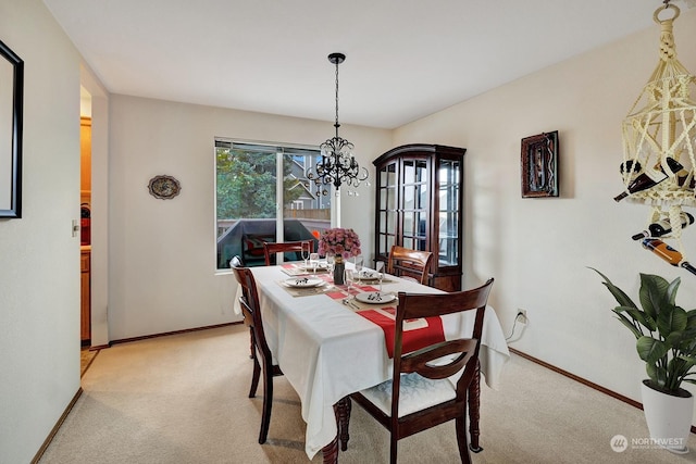 dining area with light carpet, baseboards, and a notable chandelier