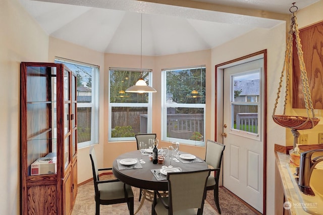 dining space with vaulted ceiling and baseboards