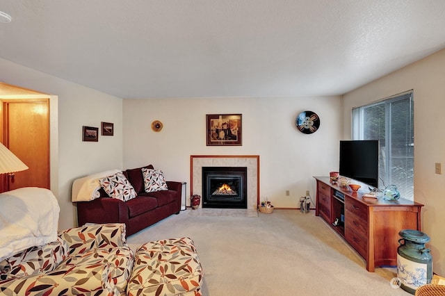 living area with light carpet, baseboards, and a tiled fireplace