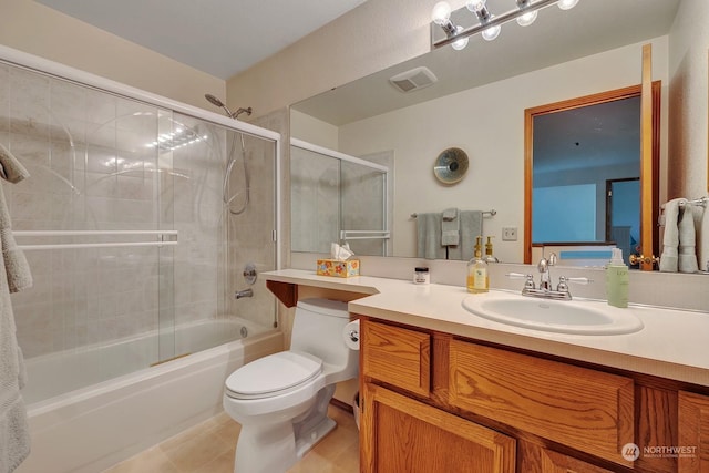 full bathroom with tile patterned flooring, toilet, vanity, visible vents, and combined bath / shower with glass door