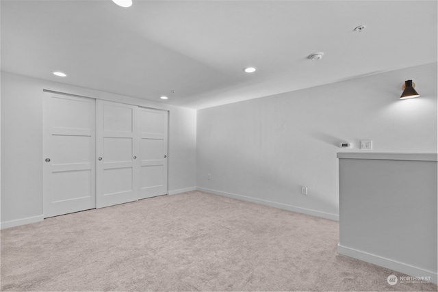 interior space featuring light colored carpet and a closet