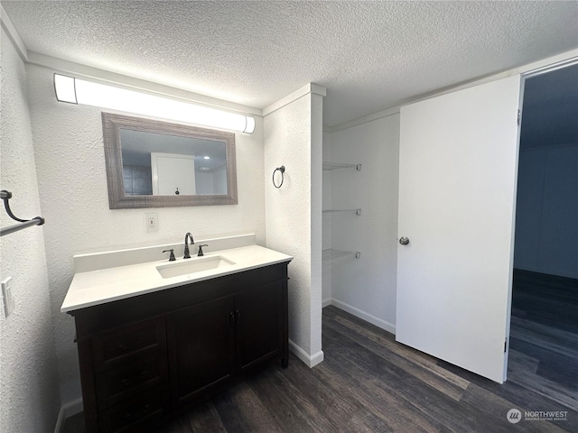 bathroom featuring hardwood / wood-style flooring, vanity, and a textured ceiling