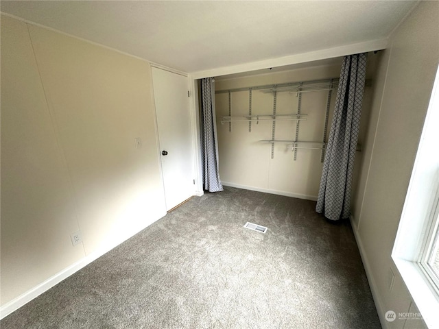 unfurnished bedroom with a closet and carpet flooring