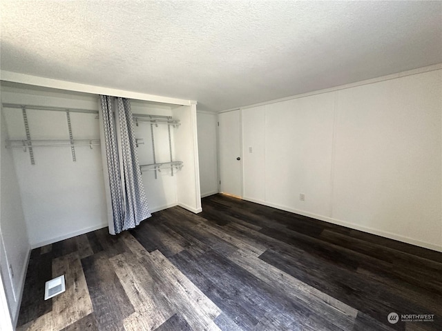 unfurnished bedroom featuring dark hardwood / wood-style floors and a textured ceiling