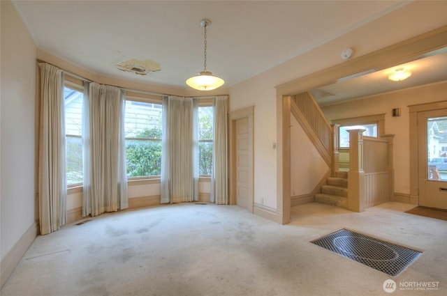 interior space featuring carpet flooring, stairway, baseboards, and ornamental molding