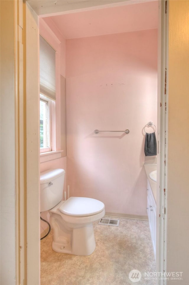 bathroom featuring vanity, toilet, and visible vents