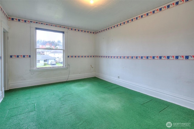 spare room with baseboards and carpet floors