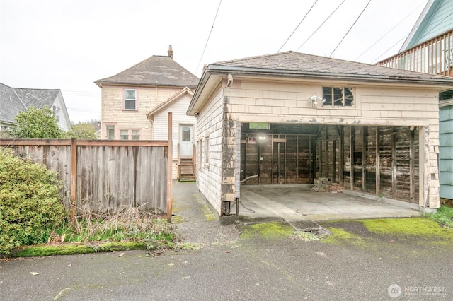 exterior space featuring fence and roof with shingles