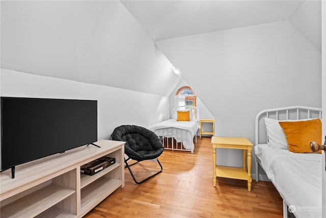 bedroom with wood-type flooring and vaulted ceiling