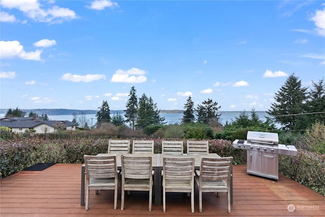 wooden deck featuring a water and mountain view and a grill