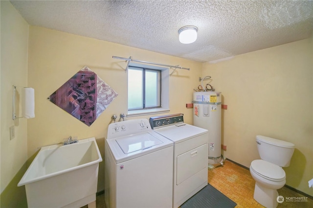 clothes washing area featuring washer and dryer, sink, secured water heater, and a textured ceiling