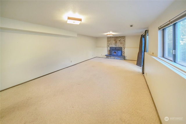 basement featuring light carpet and a wood stove