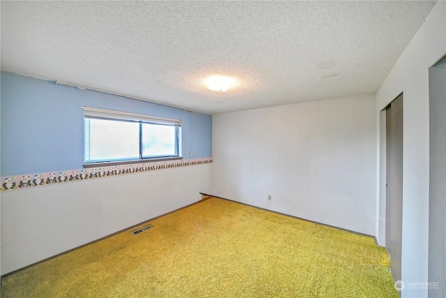 carpeted spare room with a textured ceiling