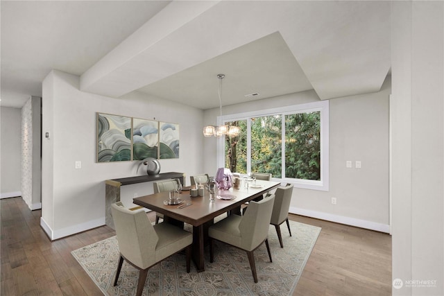 dining room with hardwood / wood-style flooring and a notable chandelier