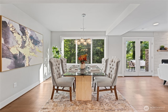 dining space with baseboards, a chandelier, a wealth of natural light, and hardwood / wood-style floors