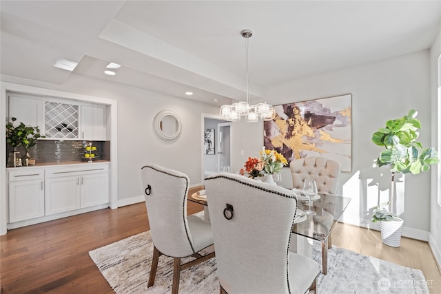 dining room featuring baseboards, recessed lighting, wood finished floors, and a chandelier