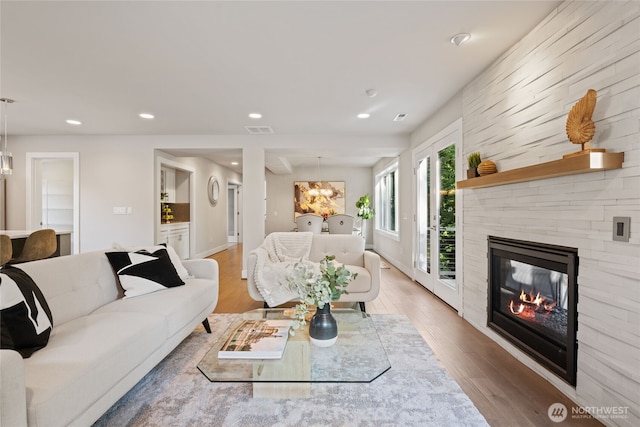 living room with an inviting chandelier, recessed lighting, visible vents, and a fireplace
