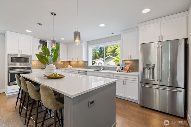 kitchen featuring a sink, a kitchen island, stainless steel appliances, and recessed lighting