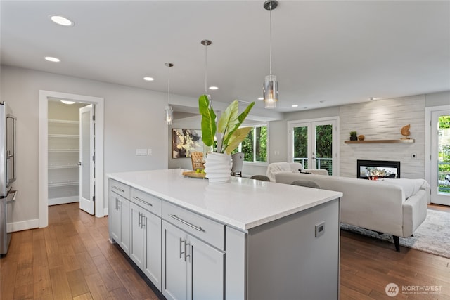 kitchen featuring a healthy amount of sunlight, light countertops, and dark wood-style floors