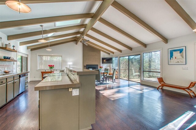 kitchen featuring open shelves, open floor plan, vaulted ceiling with skylight, tile counters, and dark wood-style flooring