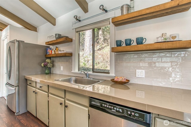 kitchen with open shelves, beam ceiling, a sink, stainless steel appliances, and tasteful backsplash