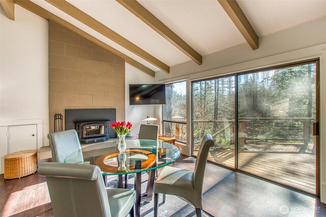 sunroom featuring a wood stove and vaulted ceiling with beams