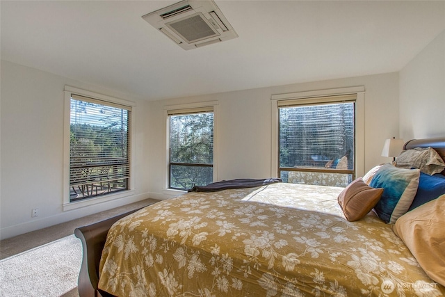 bedroom featuring baseboards, multiple windows, and carpet