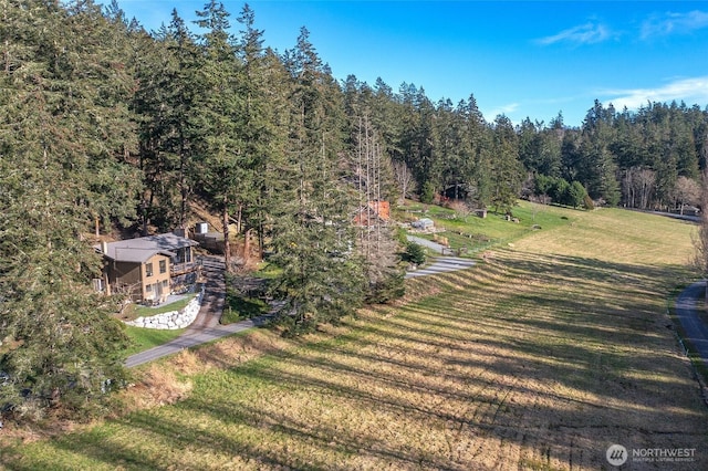 birds eye view of property featuring a forest view