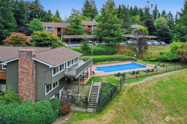 view of pool with a lawn