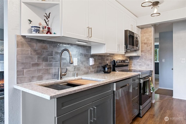 kitchen featuring white cabinetry, dark hardwood / wood-style flooring, stainless steel appliances, tasteful backsplash, and sink