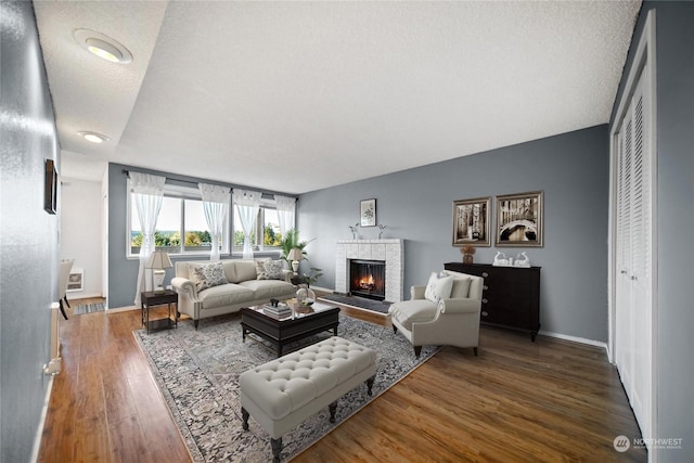 living room with dark wood-type flooring and a fireplace