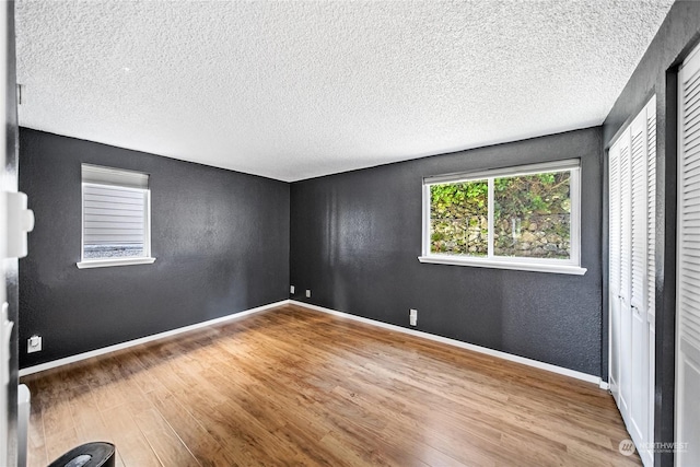 spare room with hardwood / wood-style flooring and a textured ceiling