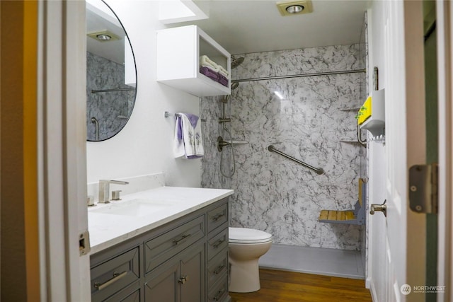 bathroom with vanity, toilet, a shower, and hardwood / wood-style floors