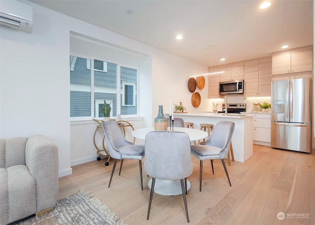 dining area with light hardwood / wood-style floors and a wall mounted air conditioner