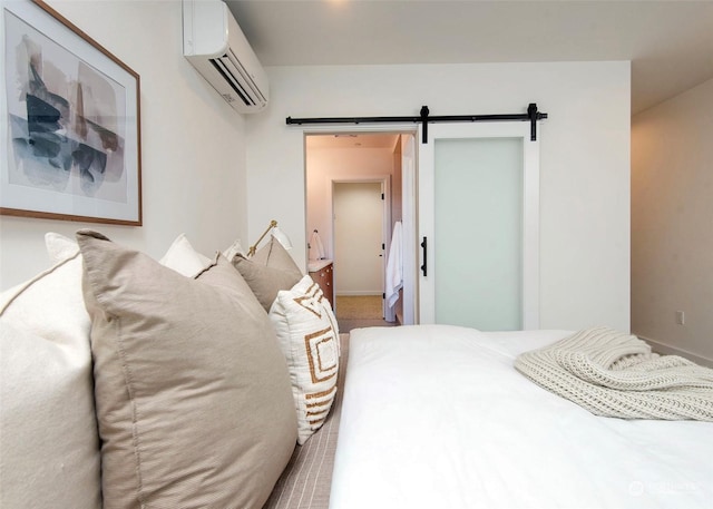 bedroom with a barn door and a wall mounted AC