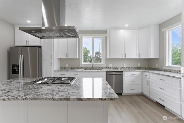 kitchen with white cabinetry, island range hood, a kitchen island, and stainless steel appliances