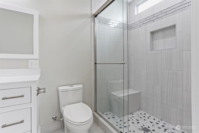 bathroom featuring a shower stall, toilet, and vanity