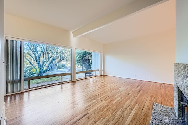 unfurnished living room featuring wood-type flooring and beamed ceiling