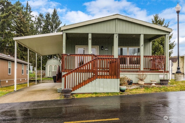 manufactured / mobile home featuring covered porch, a shed, and a carport