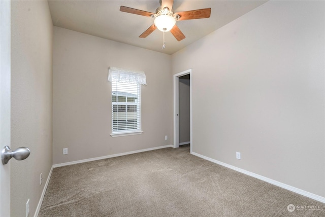 spare room with ceiling fan and carpet