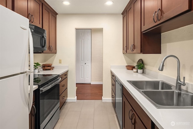 kitchen with sink, light tile patterned floors, and appliances with stainless steel finishes